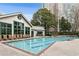 Beautiful outdoor swimming pool with clear water and brick trim, lined with lounge chairs and lush trees around at 2870 Pharr Court South Nw # 1209, Atlanta, GA 30305