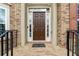 A classic brown front door with sidelights welcomes visitors into this traditional brick home at 426 Vera Park Pl, Alpharetta, GA 30022