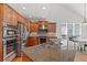 Open kitchen with stainless steel appliances, granite counters, and adjacent dining area at 426 Vera Park Pl, Alpharetta, GA 30022