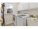 Bright laundry room with a utility sink, overhead cabinets, and modern washer and dryer at 426 Vera Park Pl, Alpharetta, GA 30022