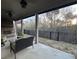Spacious covered patio with stone fireplace, seating, and serene backyard views and wrought iron fence at 432 Horizon Trl, Canton, GA 30114
