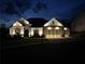 Beautifully lit home exterior featuring a stone and brick facade, complemented by an attached three-car garage at 432 Horizon Trl, Canton, GA 30114