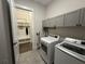 Laundry area with gray cabinets, modern washer and dryer, and a convenient entryway to a mudroom space at 432 Horizon Trl, Canton, GA 30114