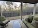 Covered back patio with outdoor seating and a view of the green backyard and trees beyond at 432 Horizon Trl, Canton, GA 30114