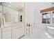 Bright bathroom features a vanity with marble countertops, ample lighting, and a window at 51 Ivy Chase Ne, Atlanta, GA 30342