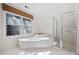 Luxurious bathroom featuring a large tub with a window and a glass-enclosed shower at 51 Ivy Chase Ne, Atlanta, GA 30342