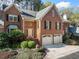 Charming two-story brick home with a well-manicured front yard and attached two-car garage, offering classic curb appeal at 51 Ivy Chase Ne, Atlanta, GA 30342