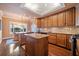 Well-lit kitchen with wood cabinets, a granite island, and stainless steel appliances at 51 Ivy Chase Ne, Atlanta, GA 30342
