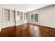 An empty living room featuring built-in shelving, hardwood floors, large windows, and detailed trim at 51 Ivy Chase Ne, Atlanta, GA 30342