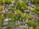 Wide aerial view of a neighborhood featuring lush green trees, houses, and a community swimming pool at 1054 Euclid Ne Ave, Atlanta, GA 30307