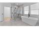 Modern bathroom with a glass shower, soaker tub, herringbone tile floor, and marble countertops at 1054 Euclid Ne Ave, Atlanta, GA 30307