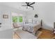 Sunlit bedroom with hardwood floors, ceiling fan, and a comfortable sitting area at 1054 Euclid Ne Ave, Atlanta, GA 30307