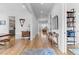 Hallway with hardwood floors, leading to various rooms, with view to kitchen with shelving, and entry to home at 1054 Euclid Ne Ave, Atlanta, GA 30307