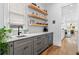 Kitchenette with gray cabinetry, floating wood shelves, marble counters, and hardwood floors at 1054 Euclid Ne Ave, Atlanta, GA 30307