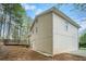 Exterior side view of the home with a deck and wooded lot at 1512 Daniel Ln, Lawrenceville, GA 30046