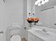 All white bathroom with white vanity and framed mirror with floral decorations at 3075 Camden Way, Alpharetta, GA 30005