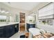 Bright bathroom boasts dual sink vanity, soaking tub, and glass enclosed shower with natural light at 4783 Deer Chase, Powder Springs, GA 30127