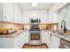 Bright kitchen features stainless steel appliances, granite countertops, white cabinets, and tile backsplash at 4783 Deer Chase, Powder Springs, GA 30127