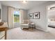 Bright bedroom featuring a cozy armchair, neutral decor, and a connecting view to another bedroom at 5607 Hislop Ln # 80, Mableton, GA 30126