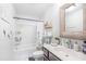 Well-lit bathroom with decorative mirror and shower with white floral curtain at 3478 Crayton Glen Way, Buford, GA 30519