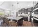 A modern kitchen features stainless steel appliances, granite countertops, and a central island with bar stool seating at 3478 Crayton Glen Way, Buford, GA 30519