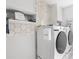 Modern laundry room with honeycomb tile backsplash, white cabinets, and new front-load machines at 3478 Crayton Glen Way, Buford, GA 30519