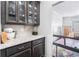 A well-organized butler's pantry features glass-front cabinets, granite countertop, and decorative accents at 3478 Crayton Glen Way, Buford, GA 30519