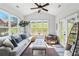 The sunroom has lots of windows, a ceiling fan, and a comfortable grey couch at 3478 Crayton Glen Way, Buford, GA 30519