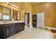 Bathroom featuring double sinks with dark wood cabinets, tile flooring, and ample storage space at 415 Damascus Ct, Fairburn, GA 30213