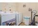 Laundry room featuring a washer, dryer, storage shelf, and tiled flooring for easy maintenance at 415 Damascus Ct, Fairburn, GA 30213