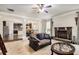 Open-concept living area with a fireplace, kitchen access, and a ceiling fan at 415 Damascus Ct, Fairburn, GA 30213