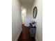 Hallway features wood floors, an oval mirror, and a blue accent table with plant at 61 N Auburn Landing Pl, Auburn, GA 30011
