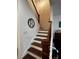 Inviting staircase with wooden steps, dark railing, and a personalized decorative monogram on the wall at 61 N Auburn Landing Pl, Auburn, GA 30011