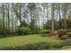 A lush backyard offers a serene view with mature trees and manicured landscaping at 1244 Arden Sw Dr, Marietta, GA 30008