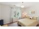 Cozy bedroom with neutral walls, yellow striped bedspread, and natural light at 1244 Arden Sw Dr, Marietta, GA 30008
