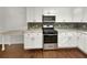 Modern kitchen with white cabinets, stainless steel appliances, and a stylish backsplash at 1879 Shamrock Dr, Decatur, GA 30032