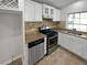 Modern kitchen with stainless steel appliances and tiled backsplash at 4425 Amy Rd, Snellville, GA 30039
