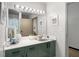Bathroom featuring a green vanity with a large mirror and modern lighting fixtures at 5200 Peachtree Rd # 2116, Atlanta, GA 30341