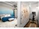 Bright main bedroom with blue accent wall, string lights, ceiling fan, and large wardrobe at 5200 Peachtree Rd # 2116, Atlanta, GA 30341