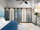 Bright main bedroom featuring a blue accent wall, ceiling fan, string lights, and large wardrobe at 5200 Peachtree Rd # 2116, Atlanta, GA 30341