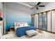 Bright main bedroom featuring a blue accent wall, ceiling fan, string lights, and large wardrobe at 5200 Peachtree Rd # 2116, Atlanta, GA 30341