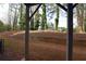 Spacious backyard area with a retaining wall and view of mature trees, offering a private outdoor space at 1494 Addison Pl, Decatur, GA 30033