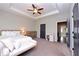 Spacious primary bedroom with tray ceiling, bench, neutral color palette, and carpeting at 1494 Addison Pl, Decatur, GA 30033