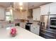 Bright kitchen featuring stainless steel appliances, a large island with quartz countertops, and modern pendant lighting at 1494 Addison Pl, Decatur, GA 30033