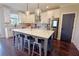 Beautiful kitchen island includes bar stool seating, stone countertop, and modern pendant lighting at 1494 Addison Pl, Decatur, GA 30033