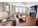 Bright living room boasts hardwood floors, a fireplace, and a comfortable sectional couch at 1494 Addison Pl, Decatur, GA 30033
