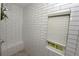 Bright tiled shower with built-in seat, niche, and window at 1494 Addison Pl, Decatur, GA 30033