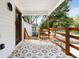Covered front porch with decorative tile flooring, wood railing, and views of the lush surroundings at 2007 Glenwood Se Ave, Atlanta, GA 30316