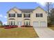 Traditional home featuring two-car garage, neutral siding, and well-maintained landscaping at 210 Millpond Pkwy, Villa Rica, GA 30180