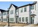 Attractive townhomes featuring a blend of white brick and siding, accented by dark window frames and awnings at 2420 Lakeshore Se Ln, Atlanta, GA 30316